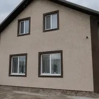 Фасад частного жилого дома с наружной отделкой Короедом